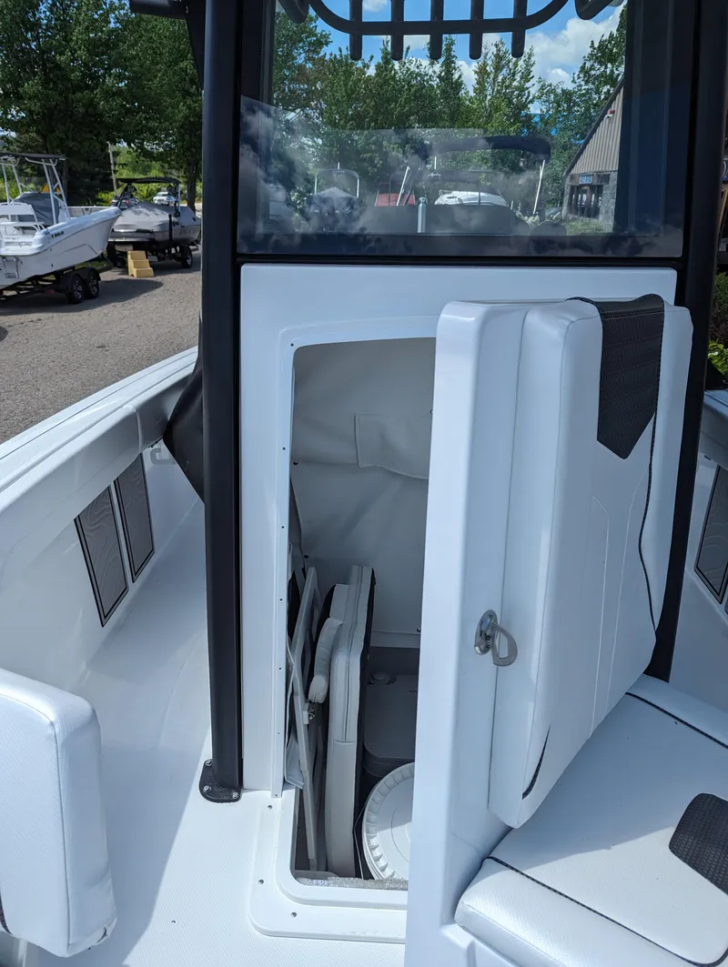 Slide: The Image of 2024 Wellcraft 223 Fisherman boat storage compartment with open door. - 6