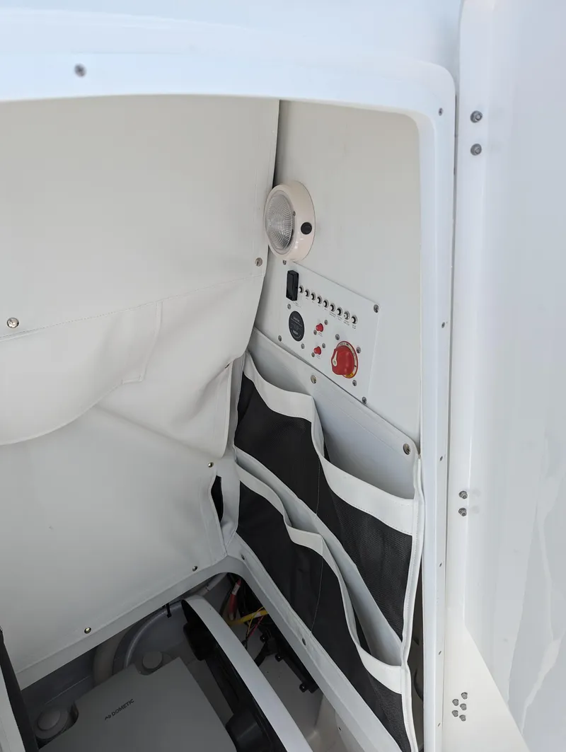 Slide: The Image of 2024 Wellcraft 223 Fisherman boat interior storage and control panel. - 7