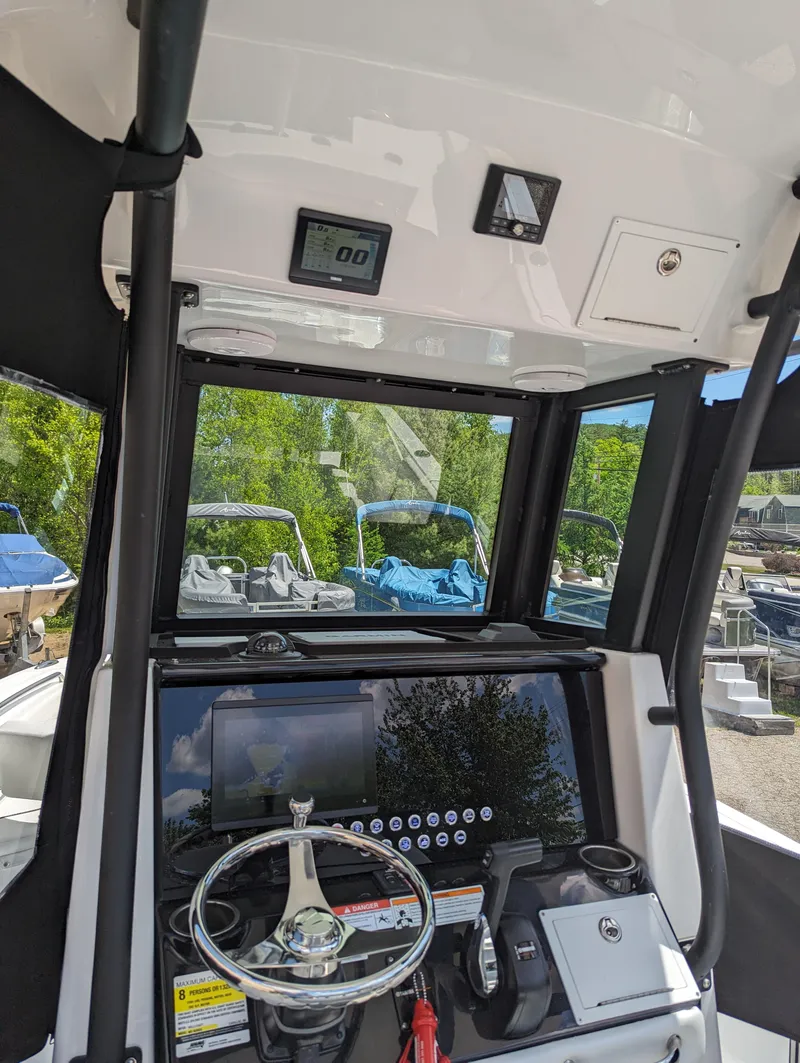 Slide: The Image of 2024 Wellcraft 223 Fisherman boat dashboard with steering wheel and control panel. - 8