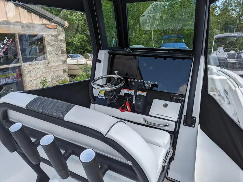 Slide: The Image of 2024 Wellcraft 223 Fisherman boat cockpit with steering wheel and control panel. - 9
