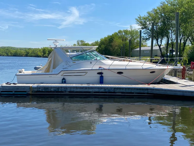 Slide: The Image of 1997 Tiara Yachts 3700 Open docked by a serene lake. - 2