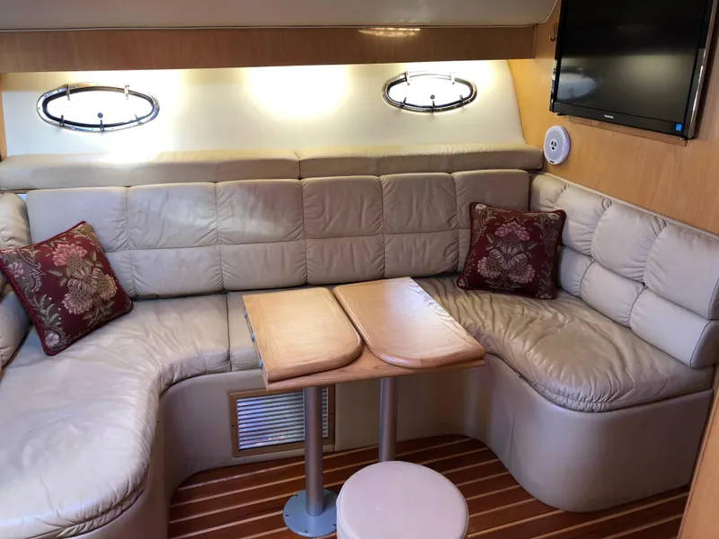 Slide: The Image of 1997 Tiara Yachts 3700 Open interior with leather seating, wooden table, and wall-mounted TV. - 22
