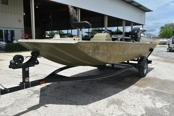 Slide: The Image of 2024 Tracker Grizzly 1754 SC fishing boat on a trailer outside a warehouse. - 28