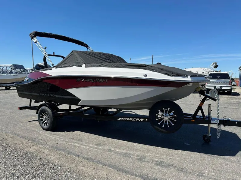 The Image of 2024 Starcraft SVX 190 OB DC boat on trailer, covered and parked outdoors. - 1