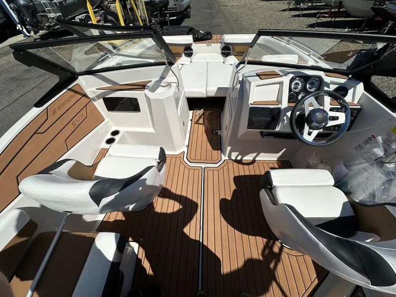 Slide: The Image of 2024 Starcraft SVX 190 OB DC boat interior with white and brown seating and dashboard. - 7