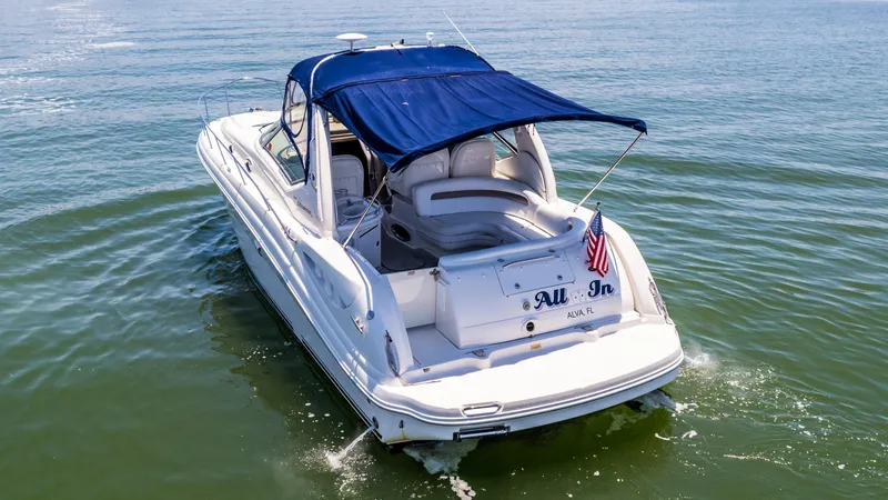 Slide: The Image of 2005 Sea Ray 340 Sundancer boat cruising on water with blue canopy. - 18
