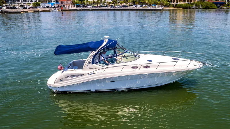 Slide: The Image of 2005 Sea Ray 340 Sundancer cruising on calm waters with a blue canopy. - 23