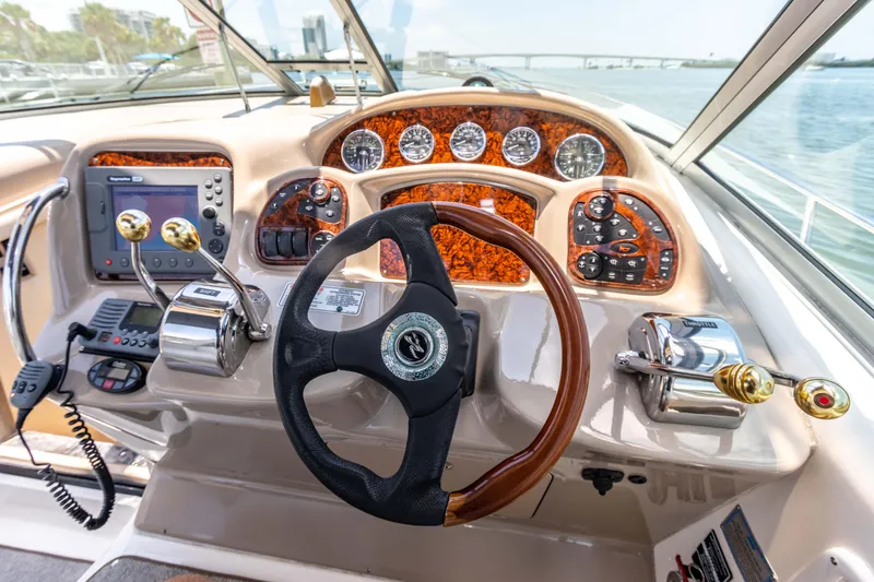 Slide: The Image of 2005 Sea Ray 340 Sundancer helm with steering wheel, gauges, and controls. - 48