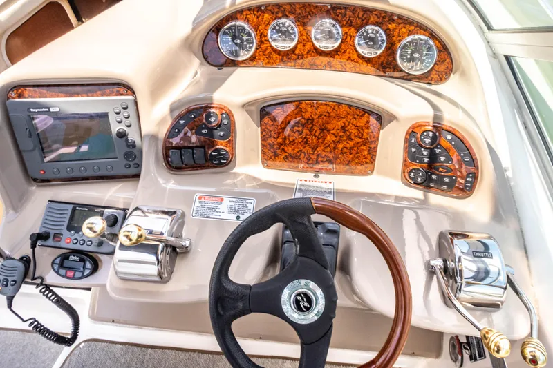 Slide: The Image of 2005 Sea Ray 340 Sundancer boat dashboard with steering wheel, gauges, and navigation equipment. - 49