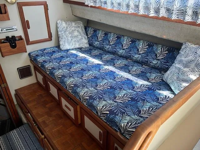 Slide: The Image of 1987 Carver Voyager interior with blue leaf-patterned cushions and wooden cabinetry. - 13