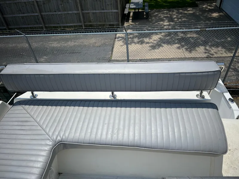 Slide: The Image of 1987 Carver Voyager boat seating with gray upholstery, outdoor setting. - 31