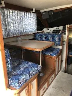 Slide: The Image of 1987 Carver Voyager interior with blue patterned seating and wooden table. - 10