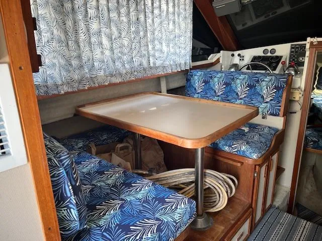Slide: The Image of 1987 Carver Voyager interior with blue leaf-patterned seating and wooden table. - 12