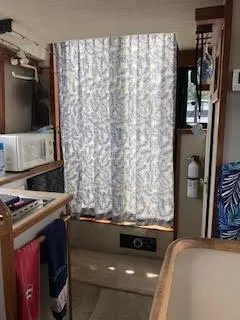 Slide: The Image of Interior of a 1987 Carver Voyager boat with kitchenette and floral curtain. - 16