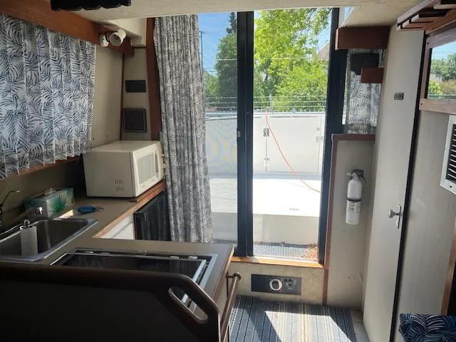 Slide: The Image of Interior of a 1987 Carver Voyager boat with kitchenette and outdoor view. - 18