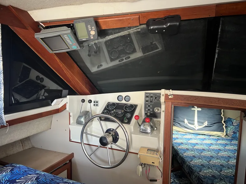 Slide: The Image of 1987 Carver Voyager helm with steering wheel, control panel, and nautical-themed interior. - 19