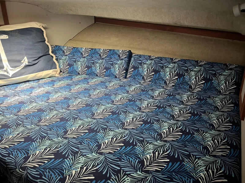 Slide: The Image of Cozy cabin bed in 1987 Carver Voyager with nautical-themed bedding and anchor pillow. - 22