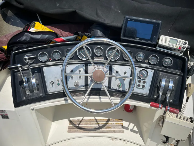Slide: The Image of 1987 Carver Voyager boat dashboard with steering wheel, gauges, and navigation equipment. - 26