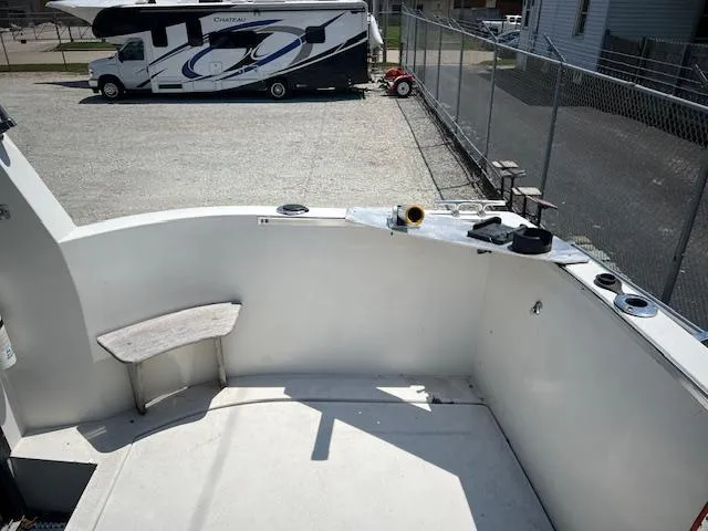 Slide: The Image of 1987 Carver Voyager boat deck with RV in background, parked in a fenced lot. - 7