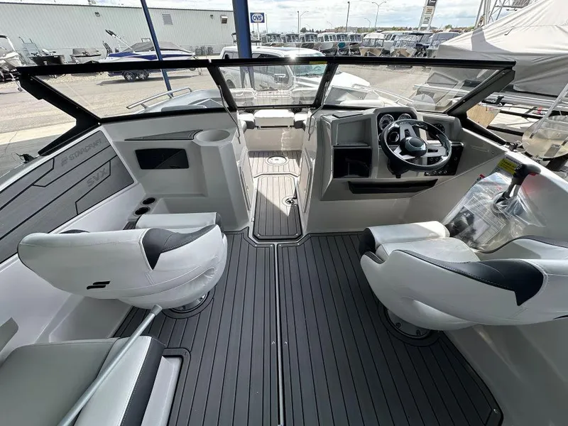 Slide: The Image of 2024 Starcraft SVX 210 OB DC boat interior with modern seating and steering console. - 7