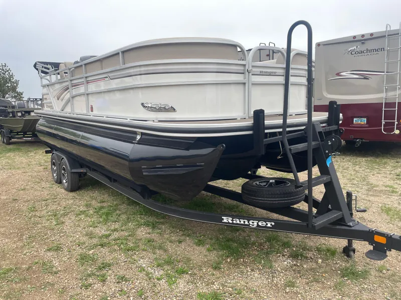 Slide: The Image of 2023 Ranger Reata 223C pontoon boat on a trailer in a parking lot. - 1