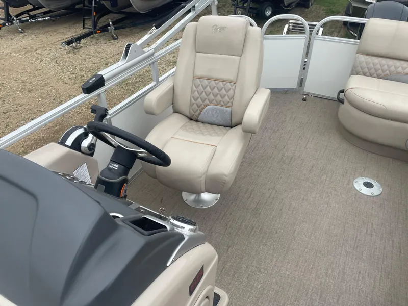 Slide: The Image of 2023 Ranger Reata 223C boat interior with beige captain's chair and steering console. - 11