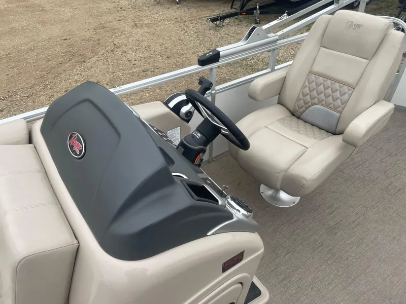 Slide: The Image of 2023 Ranger Reata 223C boat interior with captain's chair and steering console. - 12