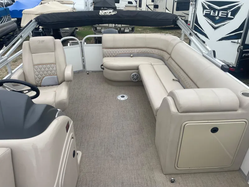 Slide: The Image of 2023 Ranger Reata 223C pontoon boat interior with beige seating and carpet. - 5
