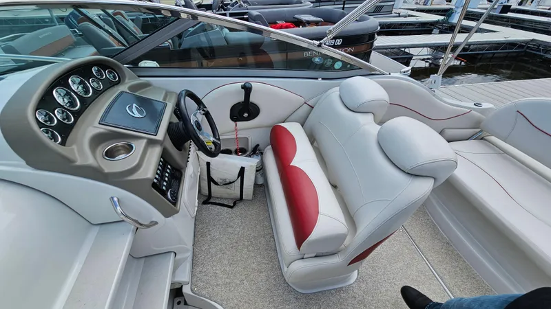Slide: The Image of 2010 Crownline 260 CR boat interior with steering console and white-red seating. - 10