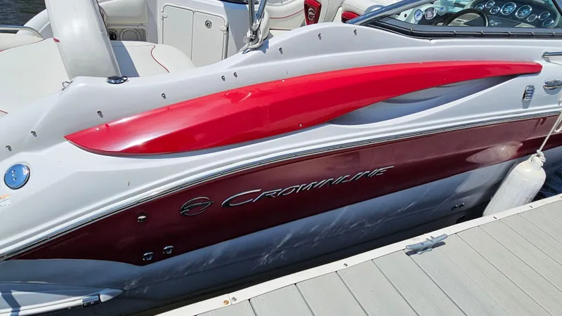 Slide: The Image of 2010 Crownline 260 CR boat docked, showcasing sleek red and white design. - 26