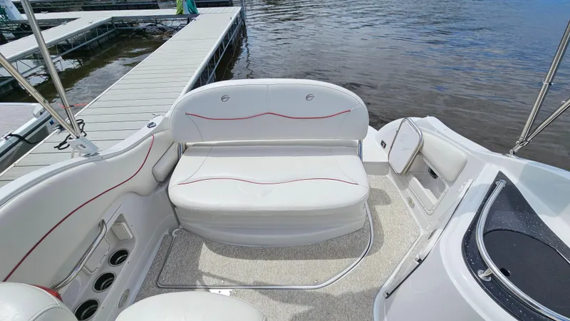 Slide: The Image of 2010 Crownline 260 CR boat interior with white seating and dock in background. - 6