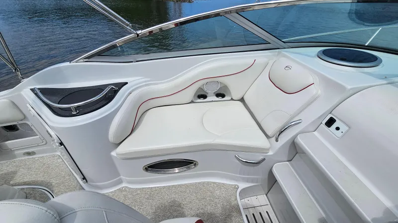 Slide: The Image of 2010 Crownline 260 CR boat interior seating with cup holders and white upholstery. - 7