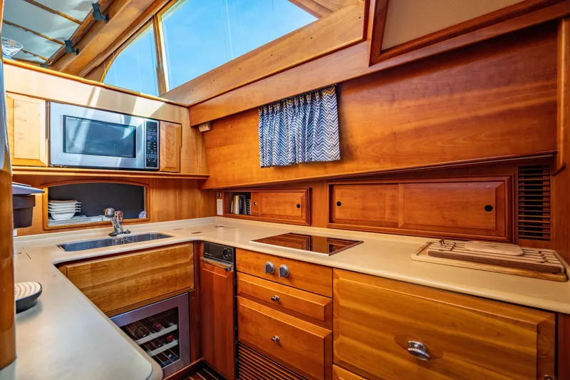 Slide: The Image of Luxurious 2007 Hinckley Talaria 55 FB yacht kitchen with wood cabinetry and modern appliances. - 19
