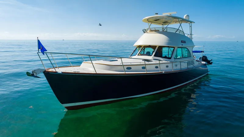Slide: The Image of 2007 Hinckley Talaria 55 FB yacht on calm ocean waters under clear blue sky. - 2