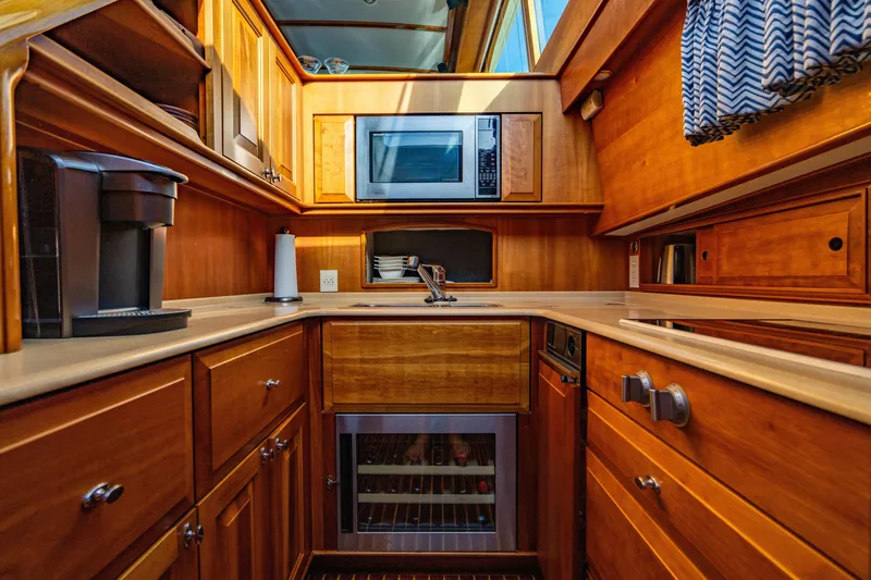 Slide: The Image of Luxurious 2007 Hinckley Talaria 55 FB yacht kitchen with wood cabinetry and modern appliances. - 20
