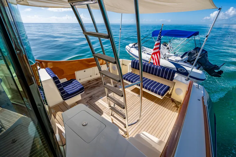 Slide: The Image of 2007 Hinckley Talaria 55 FB yacht deck with seating, ladder, and small boat. - 30