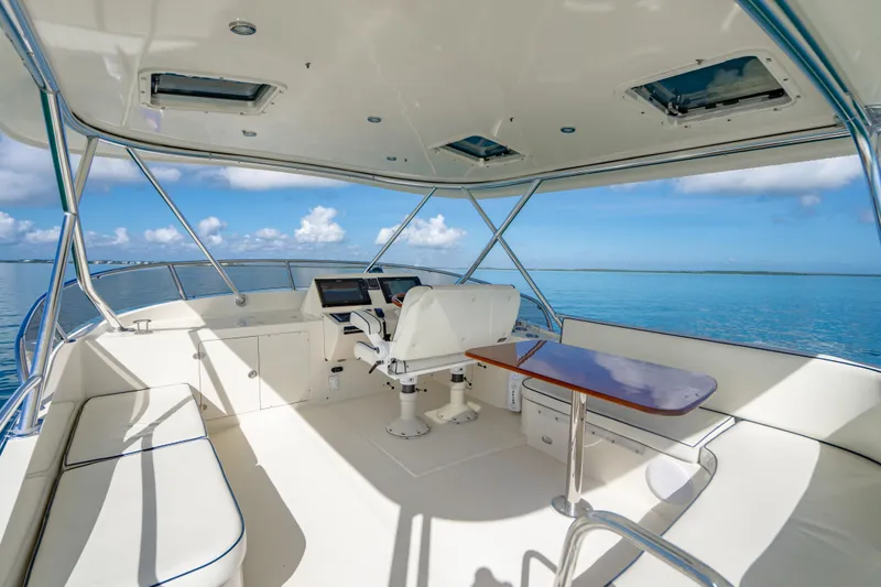 Slide: The Image of 2007 Hinckley Talaria 55 FB yacht flybridge with ocean view, featuring helm and seating area. - 32