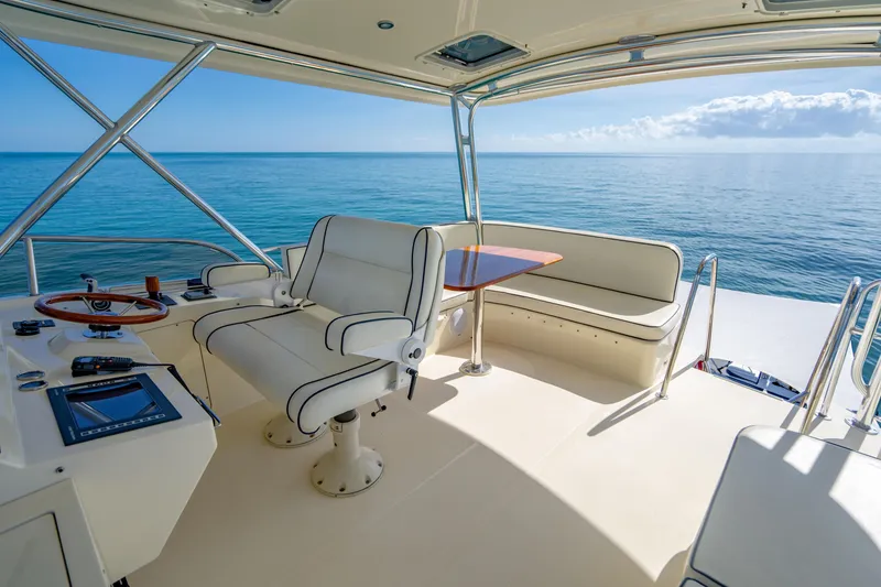 Slide: The Image of 2007 Hinckley Talaria 55 FB yacht helm with ocean view, featuring luxurious seating and navigation controls. - 36