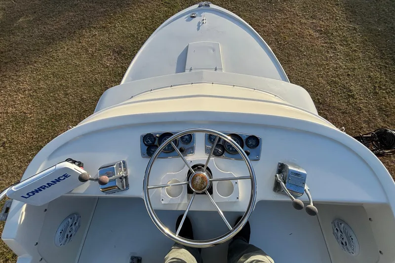 Slide: The Image of 1966 Bertram 25 boat helm with steering wheel and controls, featuring Lowrance equipment. - 11