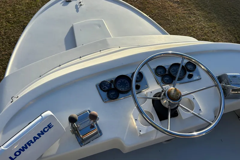 Slide: The Image of 1966 Bertram 25 boat dashboard with steering wheel and Lowrance equipment. - 14
