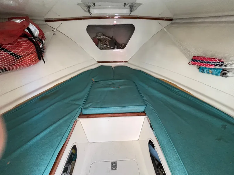 Slide: The Image of Interior cabin of a 1966 Bertram 25 boat with teal cushions and storage nets. - 5