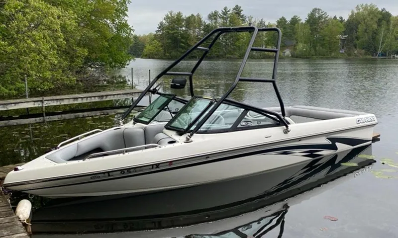 Slide: The Image of 2005 Calabria Cal-Air boat docked on a serene lake with lush greenery. - 0
