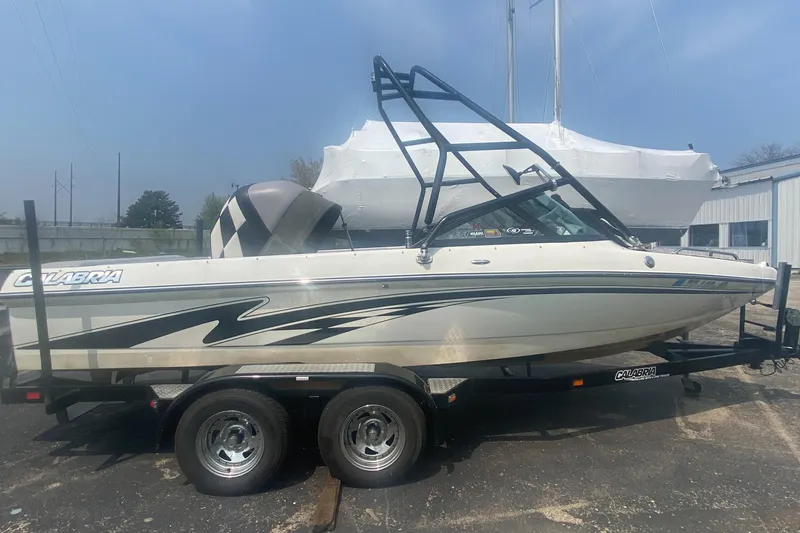 Slide: The Image of 2005 Calabria Cal-Air boat on a trailer, side view, white with black accents. - 2