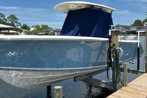 Slide: The Image of 2024 Cobia 301 Center Console boat docked on a lift. - 3