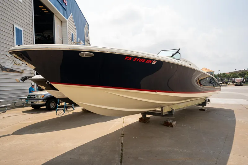 The Image of 2013 Chris-Craft Launch 32 boat on a trailer at a marina. - 0