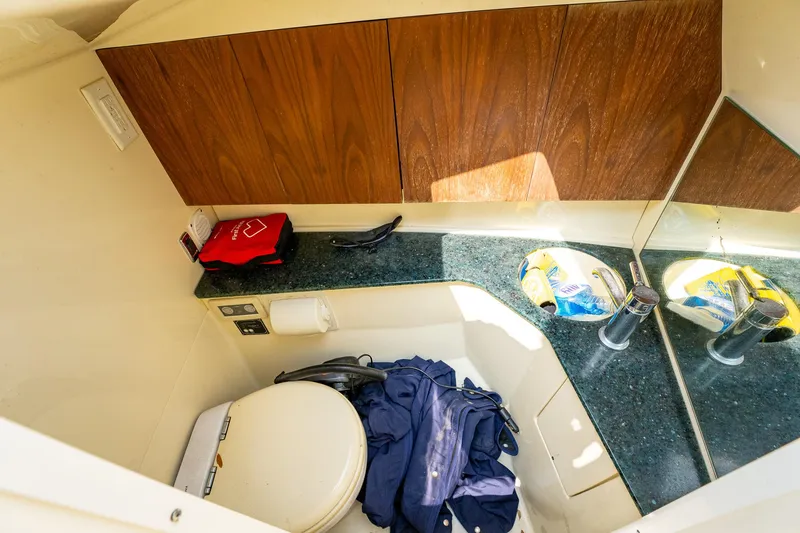 Slide: The Image of 2013 Chris-Craft Launch 32 boat bathroom with toilet, sink, and storage cabinets. - 16