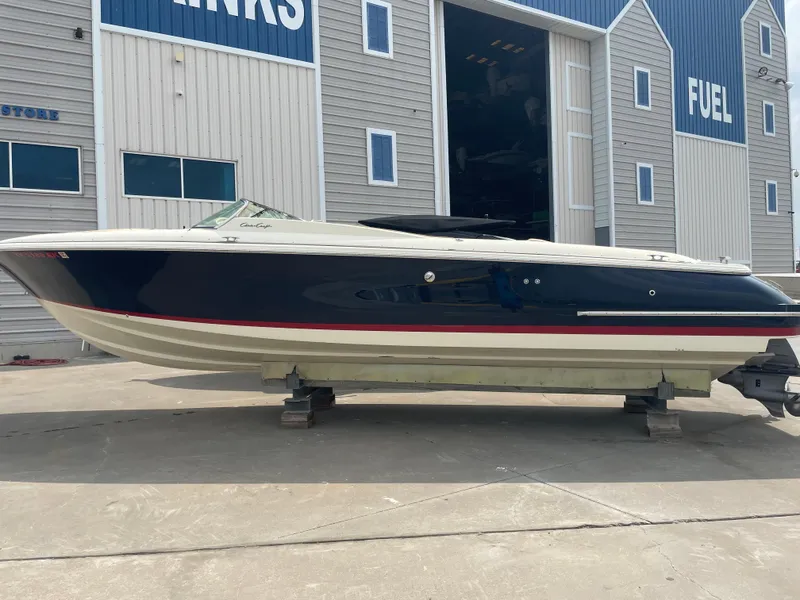 Slide: The Image of 2013 Chris-Craft Launch 32 boat on dry dock outside a marina. - 24