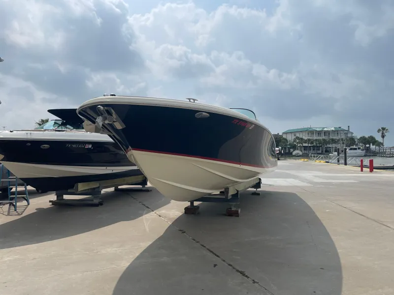 Slide: The Image of 2013 Chris-Craft Launch 32 boat on dry dock under cloudy sky. - 26