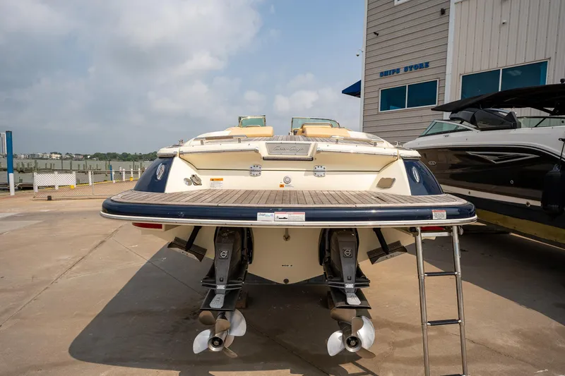 Slide: The Image of 2013 Chris-Craft Launch 32 boat docked, rear view with dual propellers and swim platform. - 3