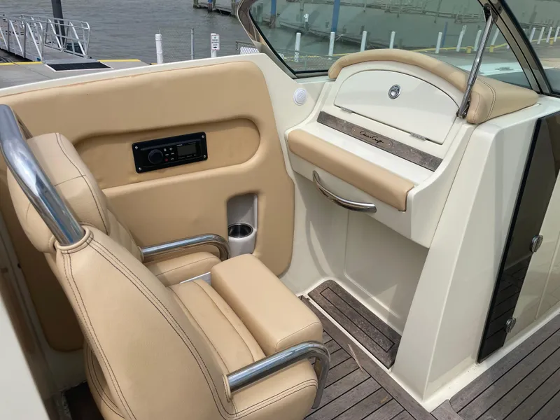 Slide: The Image of 2013 Chris-Craft Launch 32 boat interior with beige leather seats and wooden flooring. - 42